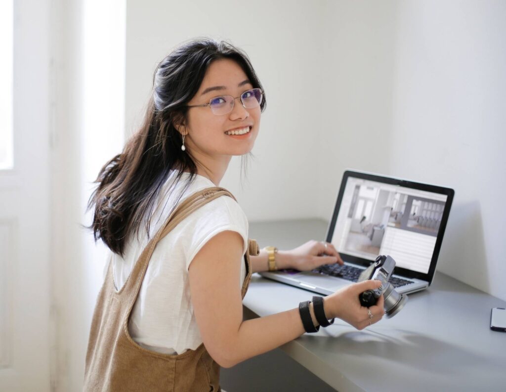 Photographer in front of laptop learning how to promote a photography business