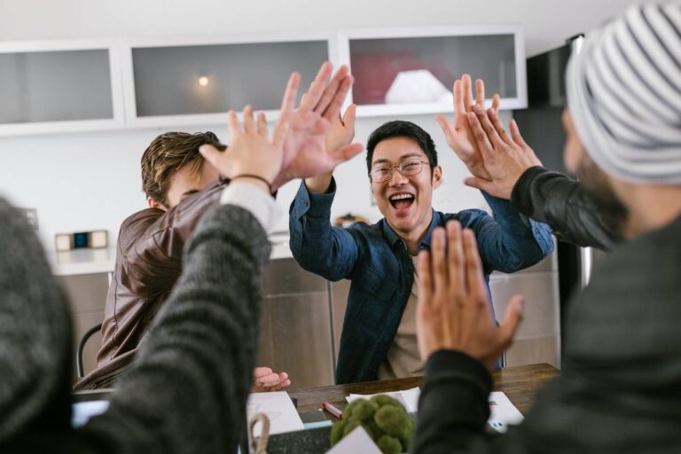 A group of people sharing a high five over a table.