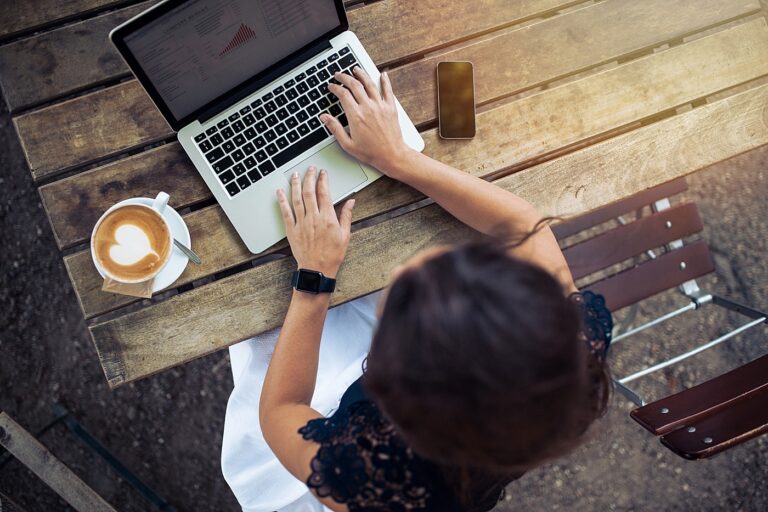 Aerial view of a woman working at a laptop with a latte