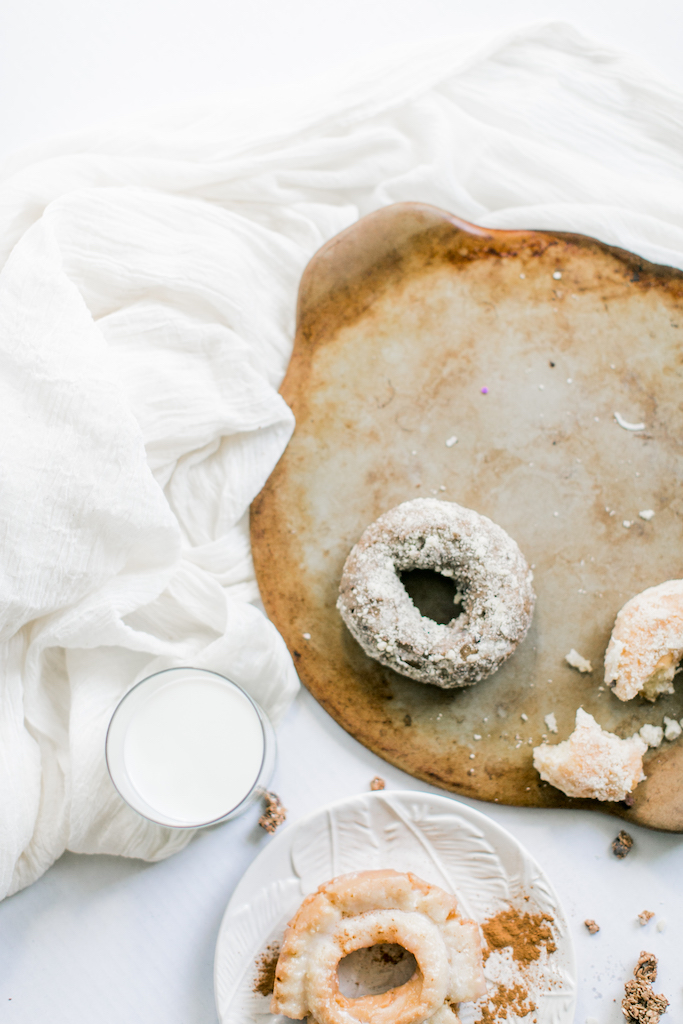 A styled shot of donuts with a glass of milk