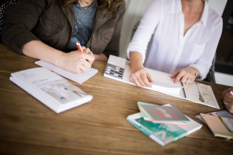 Two people at a table working on paper