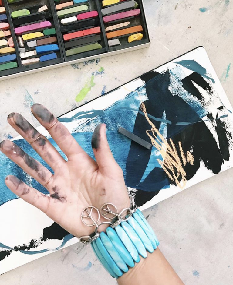 Close up of an artist's hand covered in paint.