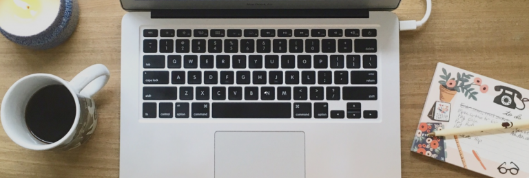 Close up of desk with laptop and coffee