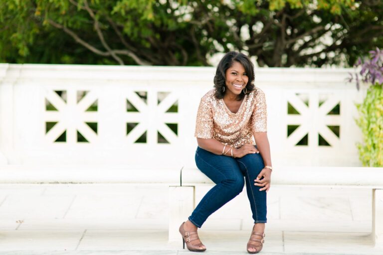 Terri Baskins sits, smiling on a park bench