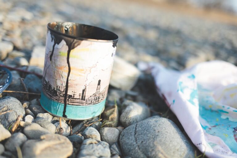 An open paint can and tarp sit on an expanse of rock