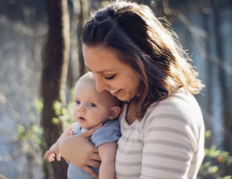a smiling woman holding a baby