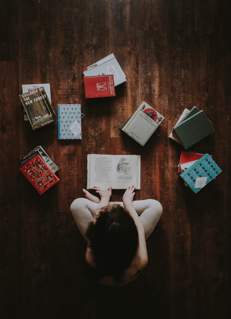 woman sitting on the floor surrounded by books