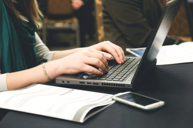 Close up of a woman working on a laptop.