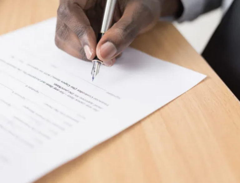 a man with a pen about to sign a copyright protection contract