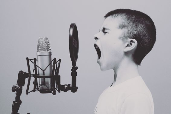 a young boy screaming into a microphone