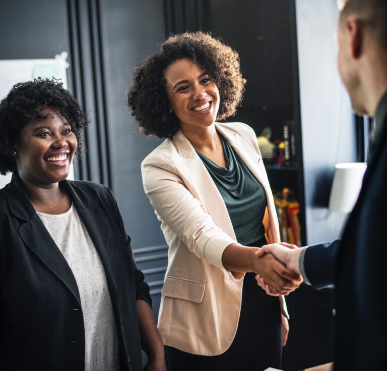 business owner and client shaking hands after a successful pitch