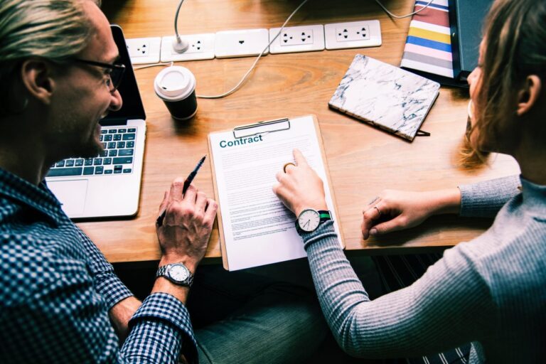 a man and woman look at documents to prepare for a trademark meeting