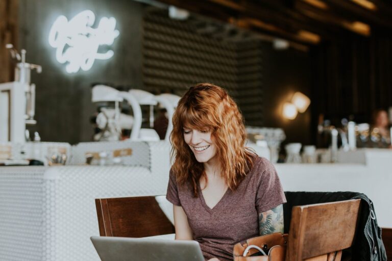 smiling woman on her laptop learning about email signature best practices