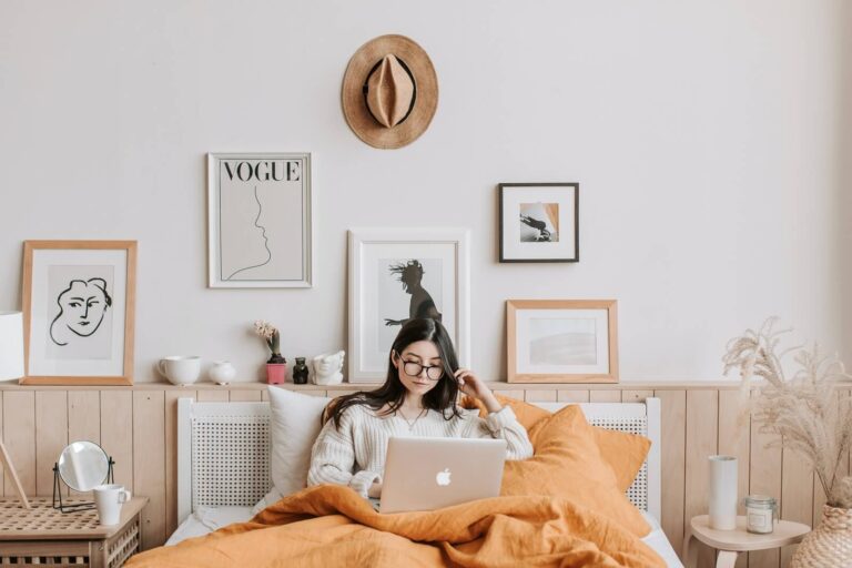 woman working on her computer in bed learning about email signature templates