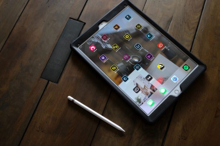 a tablet computer on a wooden desk showing an app home screen