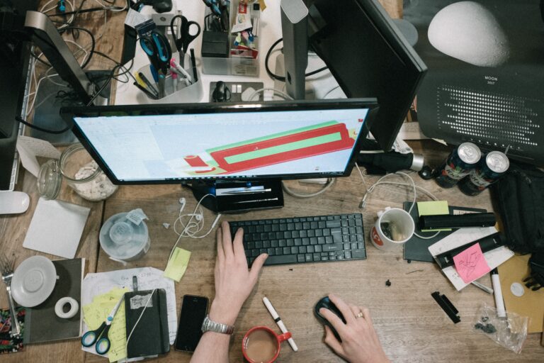a person working at a very cluttered desk