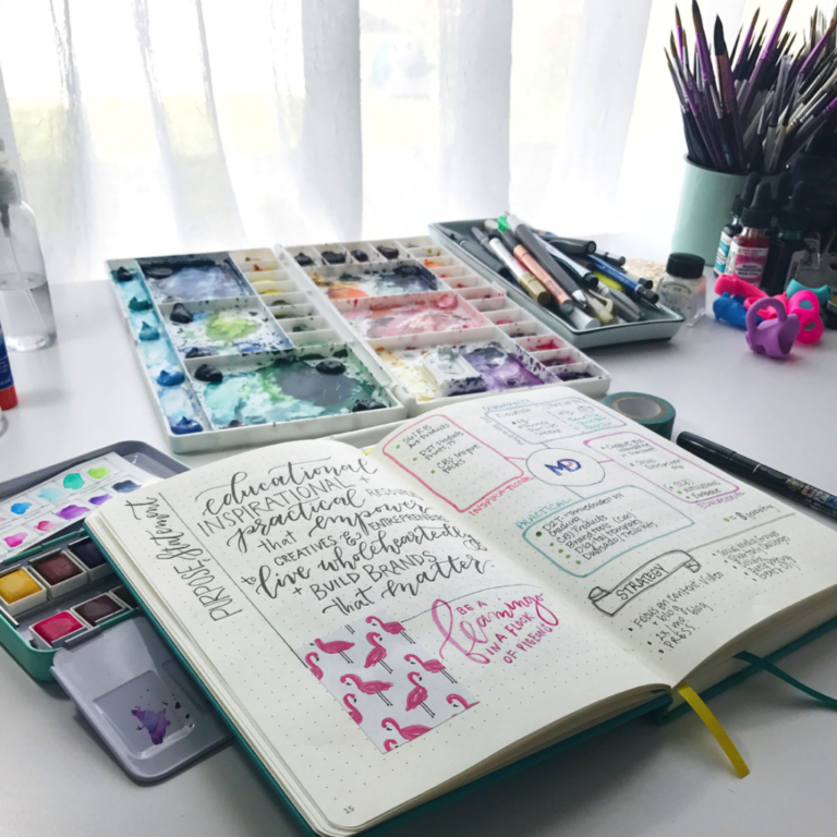 an open notebook with art supplies