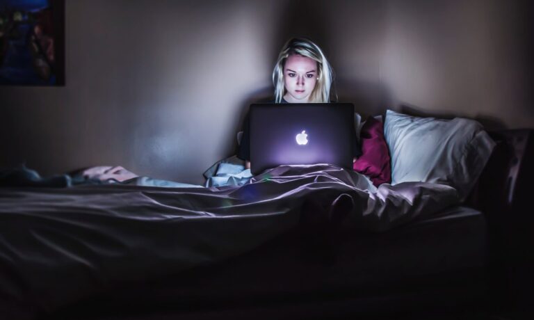 woman working on her laptop at night learning how to manage her clients