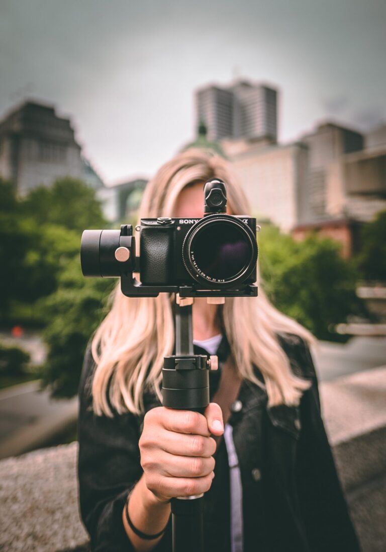 photographer holding a camera up covering her face