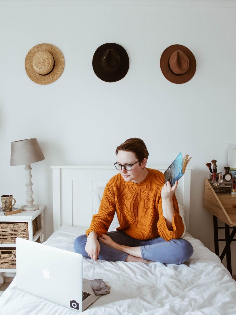 woman on a bed with a laptop learning how to create a virtual summit