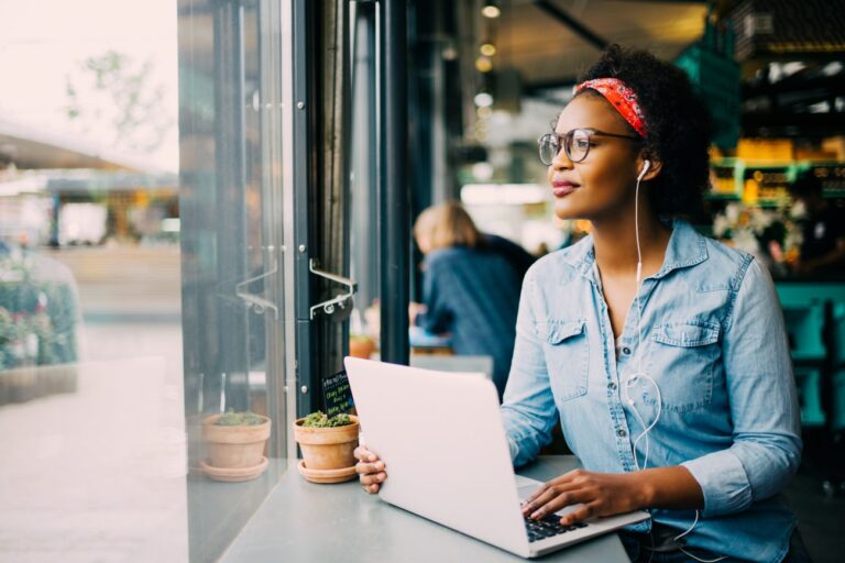 a woman wearing headphones on a laptop learning if a mastermind is right for her business