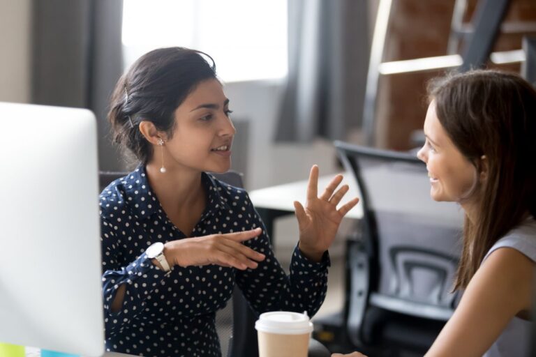 two women talking at a computer about what to look for in a business mentor