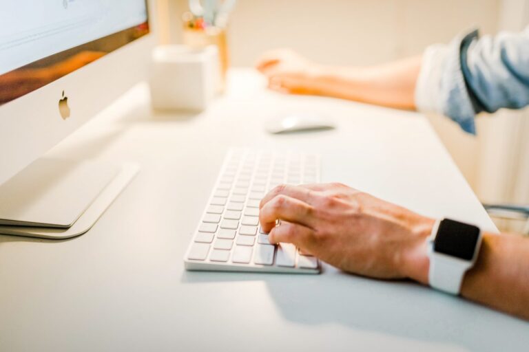 Close up of hands using a keyboard and mouse.