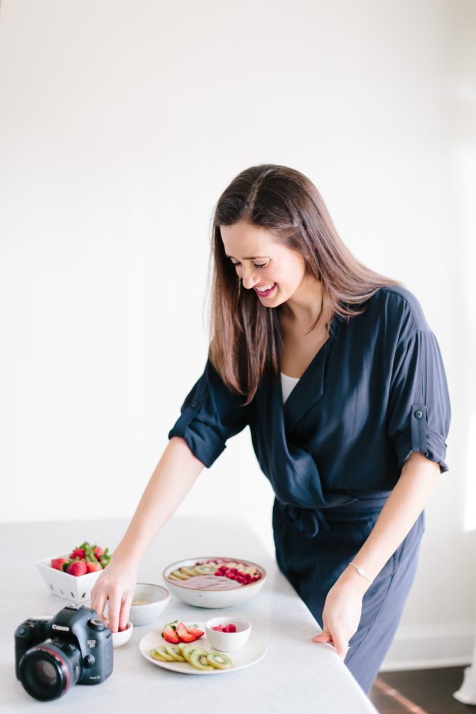 a woman arranging food on plates next to a camera