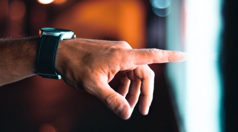 a hand with a wristwatch pointing to a light area