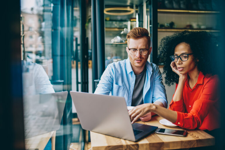 manager teaching time management tricks to an employee on a laptop