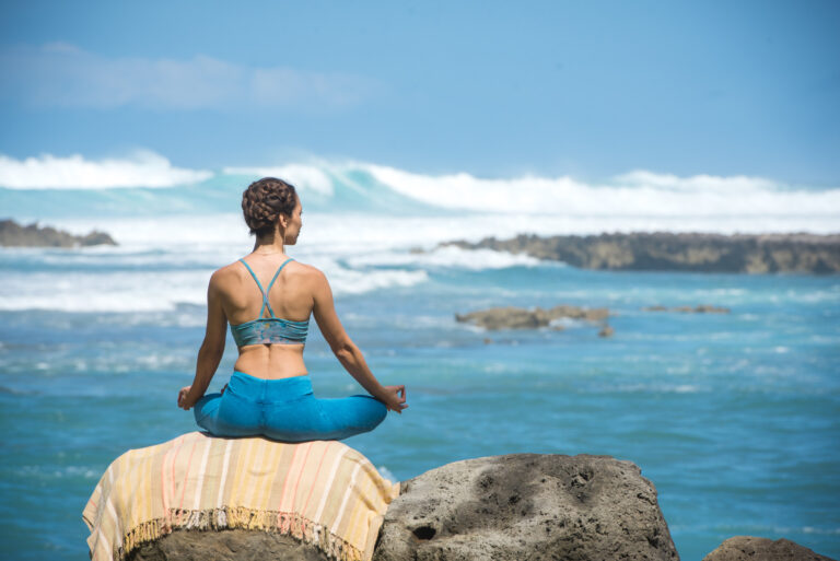 person practicing meditation while looking at the ocean