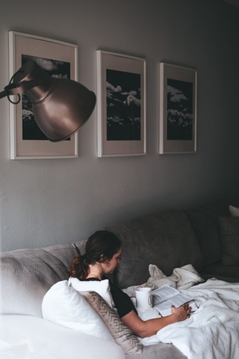 person reading and having coffee on the couch