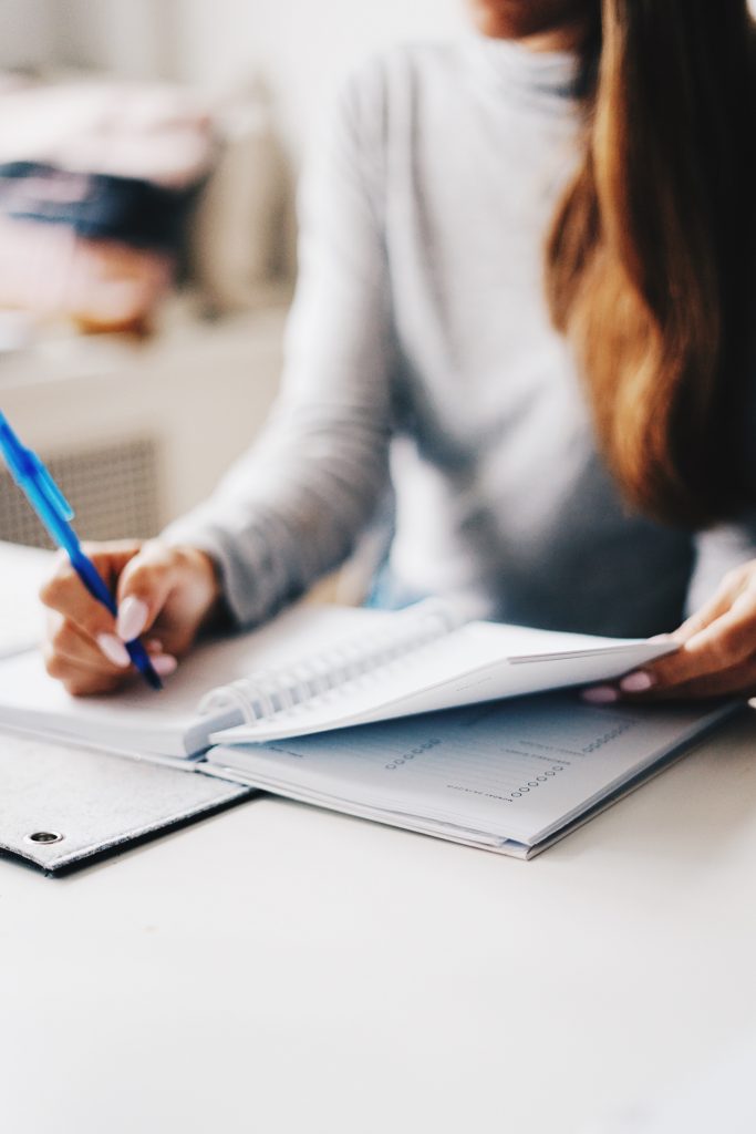 Woman writing down goals into a notebook.