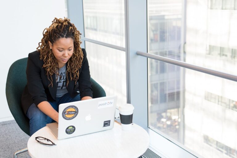 Woman in an office building working at her laptop.