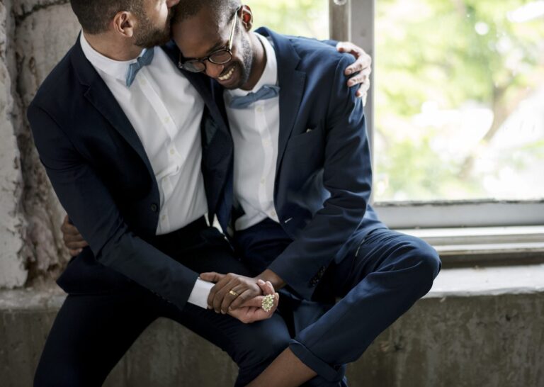 two men smiling and laughing at their wedding