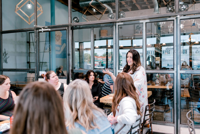 person giving a presentation to a group of people in a coffee shop