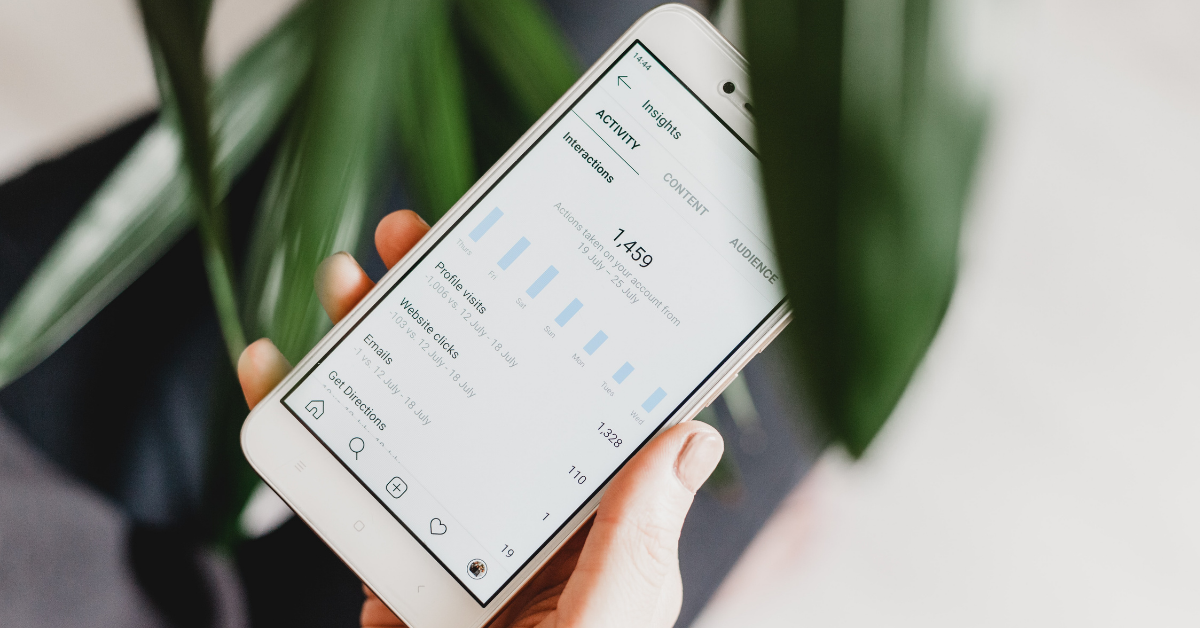 Photo of an iPhone in someone's hand showing Instagram profile analytics
