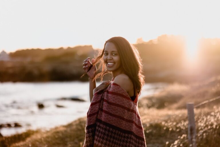 a woman posing for a photo in front of a lake