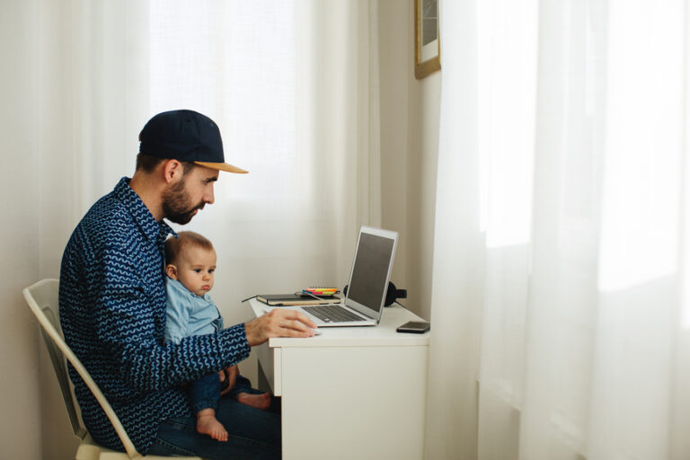 a freelancer at a laptop with a baby on his lap learning how to plan rest