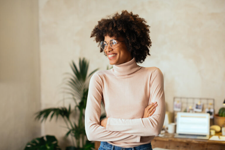 a woman smiling and learning how to create a podcast