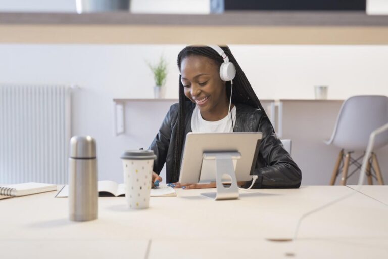 a woman on a laptop with headphones learning how to pitch podcasts