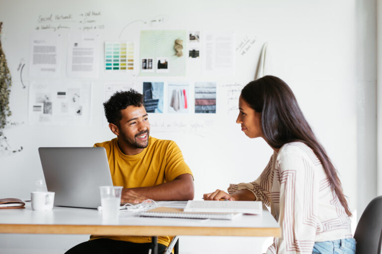 A man and woman work together at a table.