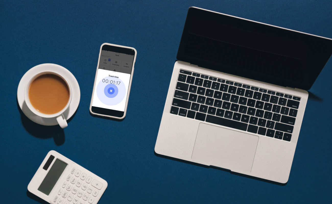 Table showing best time tracking app next to coffee cup and laptop
