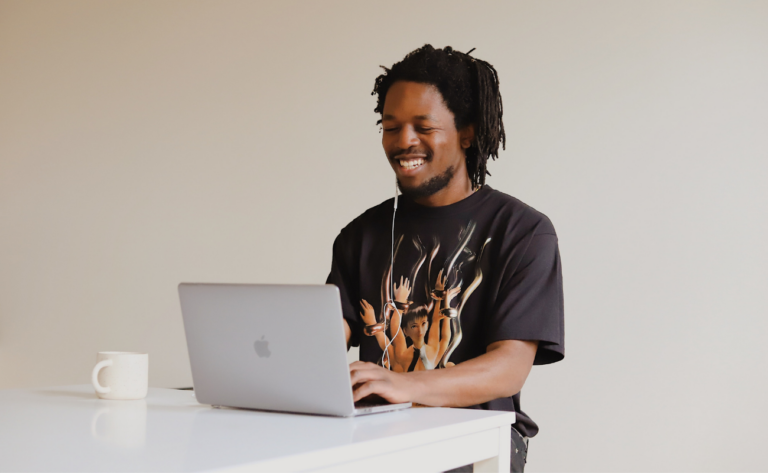 Young African American man smiling at laptop