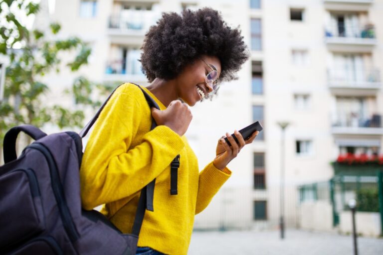 woman walking down the street looking at her phone