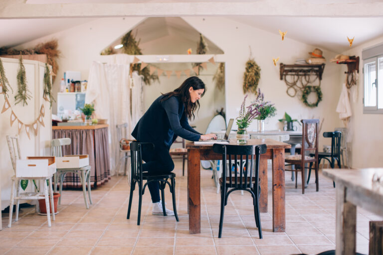 Brunette woman working with the laptop in her eco farm.