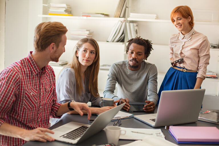 Young coworkers discuss around a table.