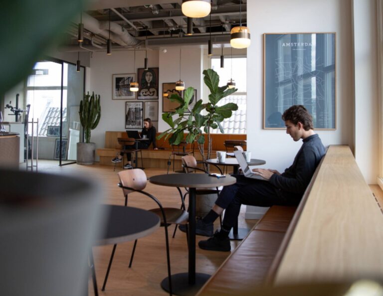 person working at a coffee shop on their laptop