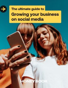 Two women look at a phone on the cover of Growing your business on social media guide.