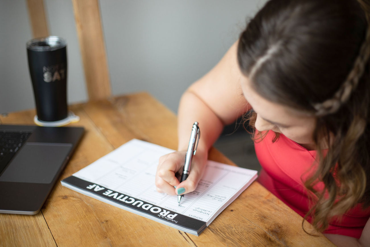 Woman working on block scheduling in a paper calendar